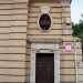 ...la cui simmetria  per spezzata da un piccolo corpo di fabbrica leggermente rientrante rispetto al resto. Qui  presente anche un accesso secondario chiuso in una cornice decorata, sovrastata da unapertura ovale con inferriata a volute...